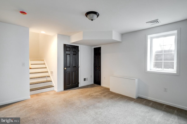 basement with visible vents, baseboards, carpet, and stairway