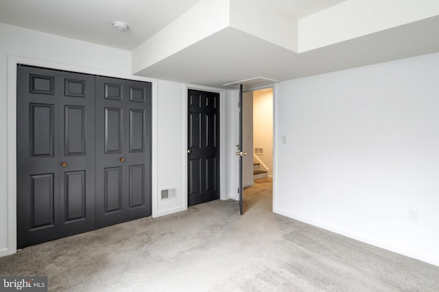 unfurnished bedroom with visible vents, baseboards, a closet, and carpet flooring