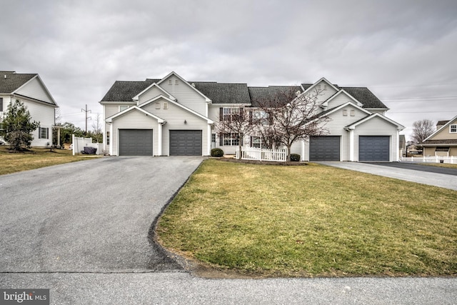 view of front of home featuring a front yard, fence, a garage, and driveway