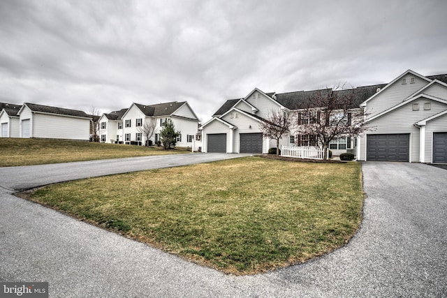 view of front of house with aphalt driveway, a residential view, and a front yard