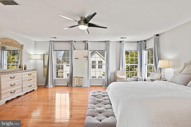 bedroom featuring visible vents, light wood finished floors, and ceiling fan