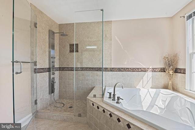 bathroom featuring a bath, a shower stall, and tile patterned flooring