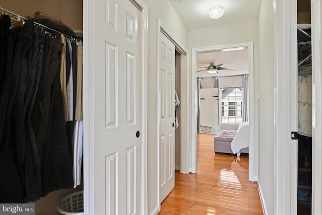 hall with light wood finished floors and baseboards