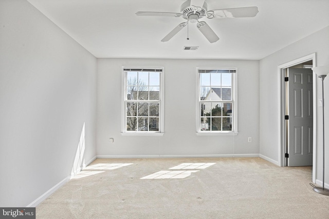 spare room featuring carpet flooring, baseboards, and visible vents