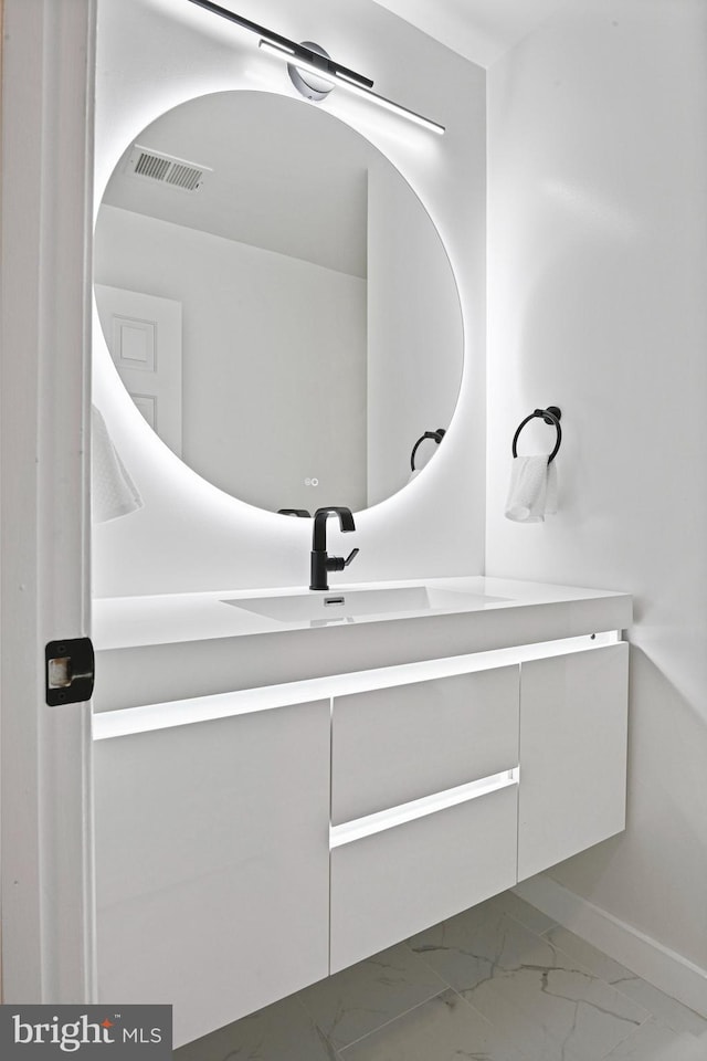 bathroom with visible vents, baseboards, marble finish floor, and vanity