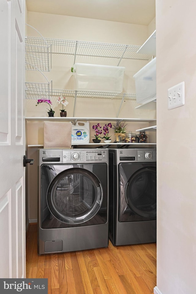 laundry room featuring laundry area, independent washer and dryer, and light wood-style floors