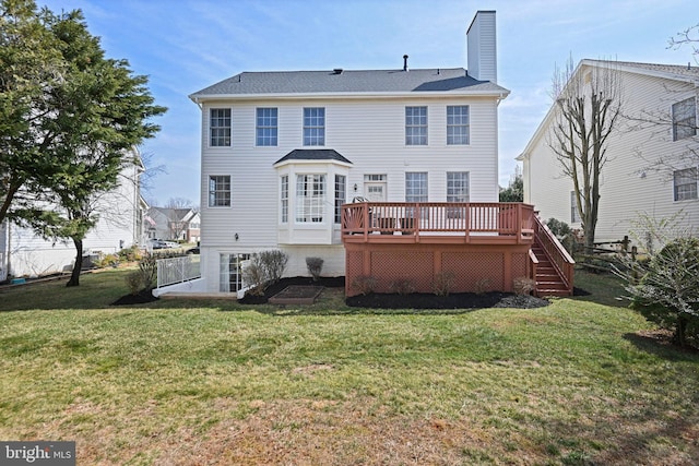 back of house featuring a deck, a chimney, a yard, and fence