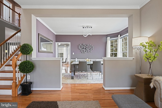 foyer featuring ornamental molding, stairs, baseboards, and wood finished floors