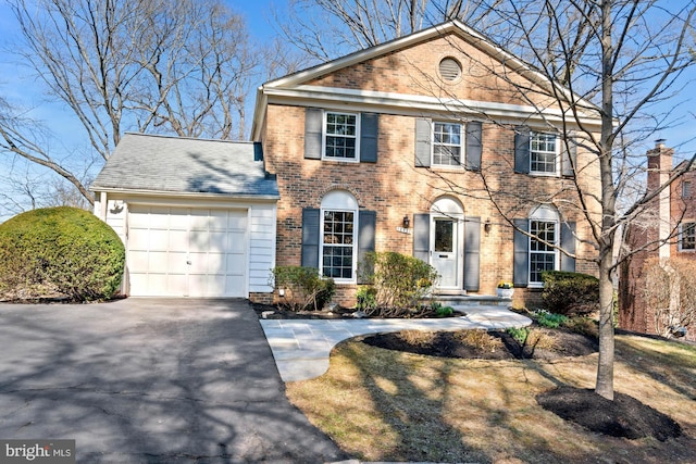 view of front facade featuring an attached garage, brick siding, and driveway