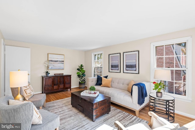 living area with light wood-style flooring and baseboards