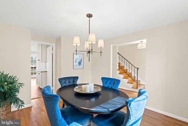 dining room with stairs, wood finished floors, and baseboards