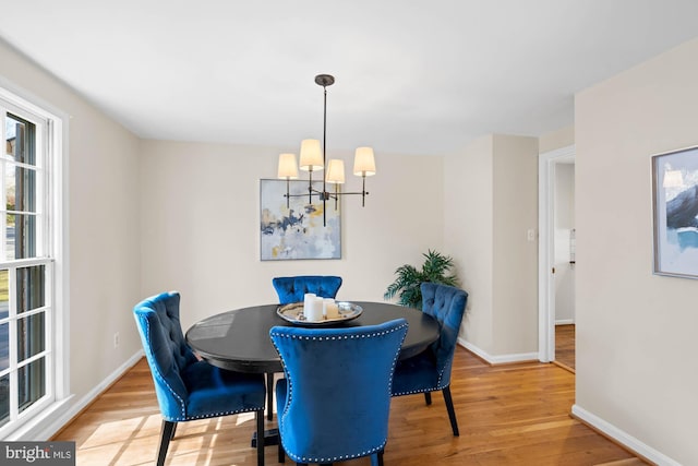 dining room featuring baseboards, an inviting chandelier, and wood finished floors