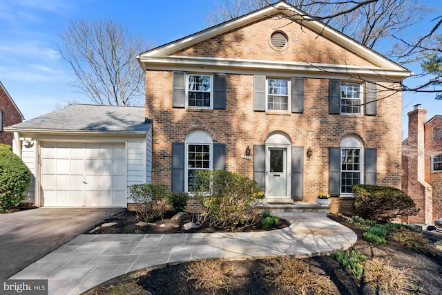 view of front of home with a garage, brick siding, and concrete driveway