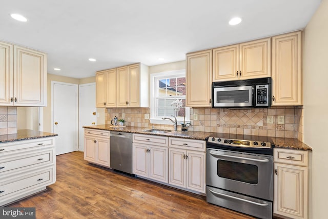 kitchen with cream cabinetry, stainless steel appliances, and a sink