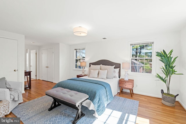 bedroom featuring visible vents, wood finished floors, and baseboards