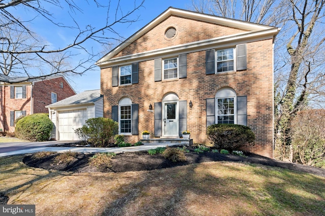 view of front of home featuring a garage, brick siding, and driveway