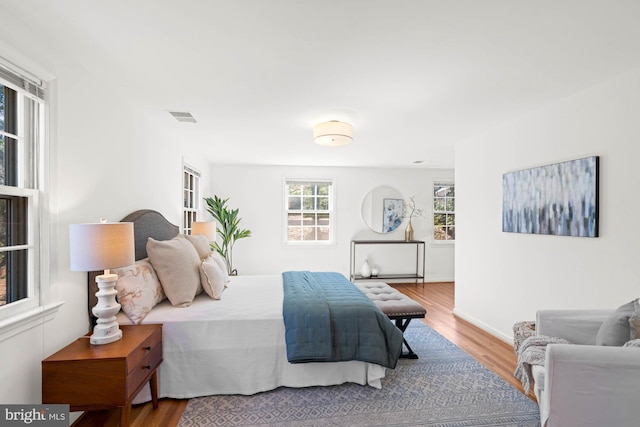 bedroom featuring visible vents and wood finished floors