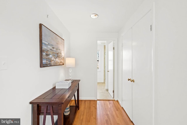 hall featuring baseboards and light wood-style flooring