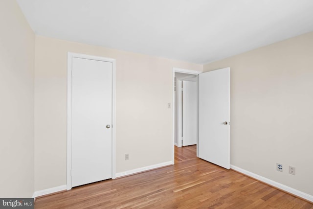 unfurnished bedroom featuring wood finished floors and baseboards