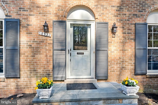 property entrance featuring brick siding