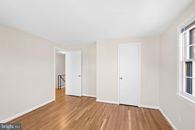 spare room featuring baseboards and wood finished floors