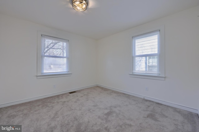 carpeted empty room with baseboards and visible vents