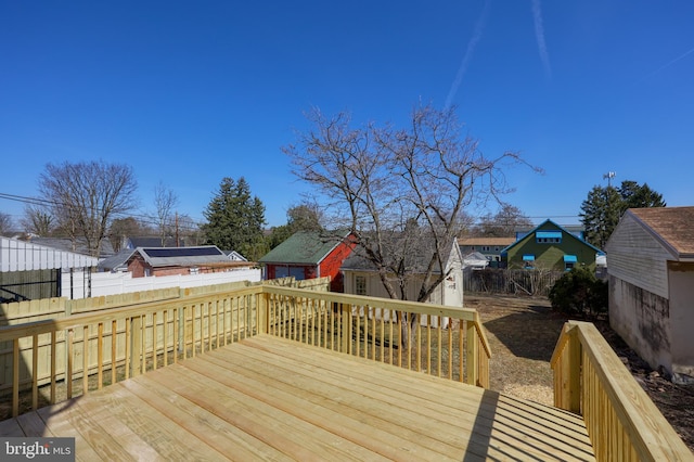 wooden deck featuring a residential view, an outdoor structure, and fence