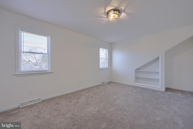 interior space featuring built in features, visible vents, and baseboards