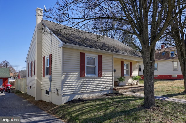 view of front facade featuring a front lawn and a chimney