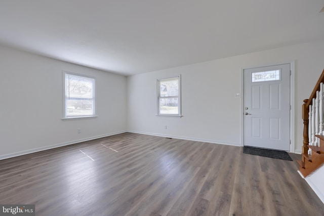 entrance foyer featuring stairway, dark wood-style floors, baseboards, and a wealth of natural light