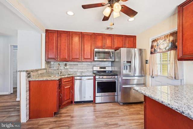 kitchen featuring visible vents, backsplash, stainless steel appliances, and a sink