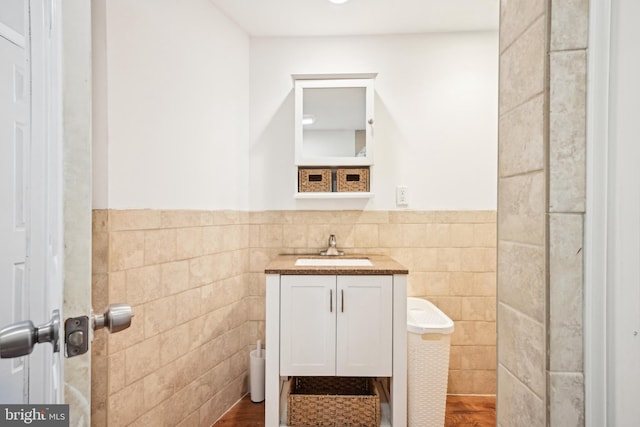 bathroom featuring vanity, tile walls, and wainscoting