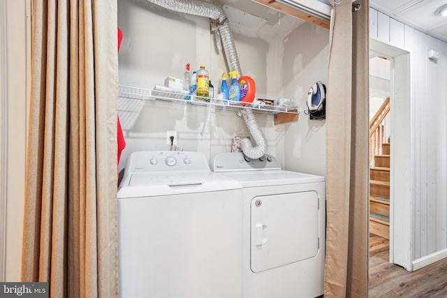 laundry area with washer and dryer, wood finished floors, and laundry area