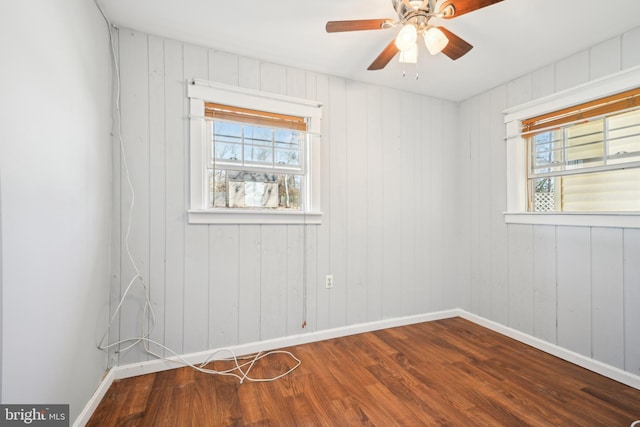 unfurnished room featuring wood finished floors, baseboards, and ceiling fan