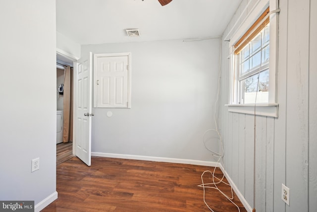 unfurnished room with baseboards, washer / dryer, and wood finished floors