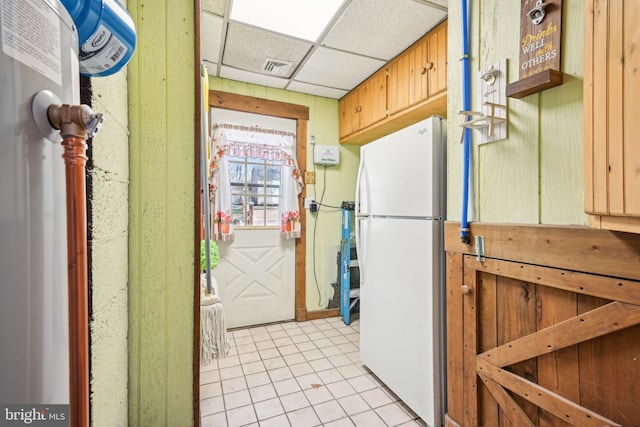 kitchen featuring light tile patterned floors, a paneled ceiling, visible vents, and freestanding refrigerator