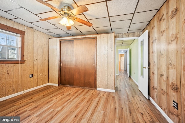 unfurnished bedroom with wooden walls and wood finished floors