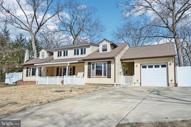 view of front of property with fence, concrete driveway, roof with shingles, covered porch, and a garage