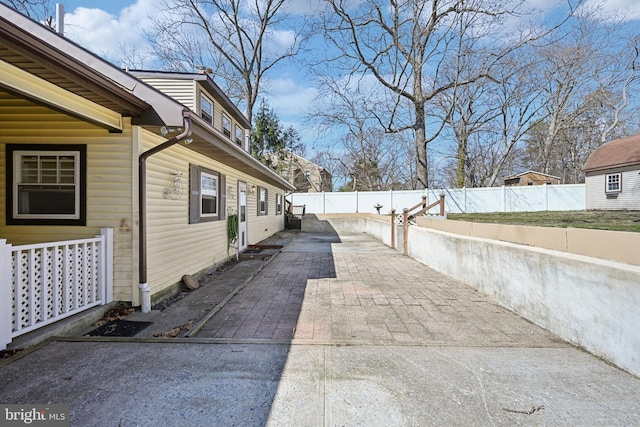 view of side of property featuring a fenced backyard and a patio