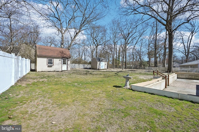 view of yard featuring an outbuilding, a storage shed, and a fenced backyard