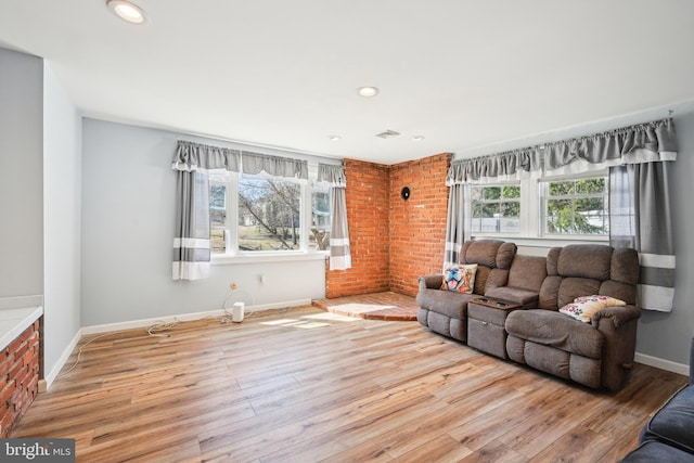 living room featuring a healthy amount of sunlight, baseboards, and wood finished floors