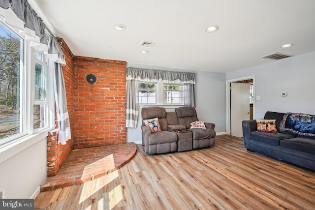 living room with recessed lighting, visible vents, and wood finished floors