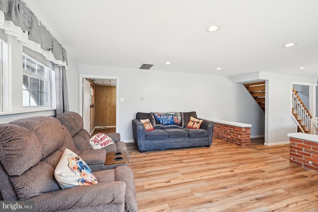 living area with recessed lighting, visible vents, stairs, and light wood finished floors