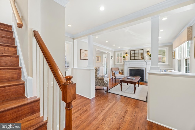 interior space featuring a brick fireplace, recessed lighting, light wood-type flooring, and ornamental molding