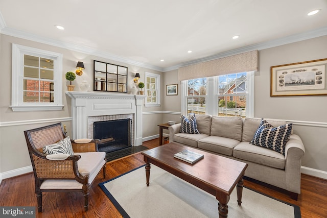 living area with a brick fireplace, crown molding, baseboards, and wood finished floors