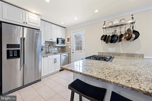 kitchen with crown molding, white cabinets, appliances with stainless steel finishes, and a sink