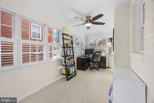 carpeted home office with baseboards, brick wall, and ceiling fan