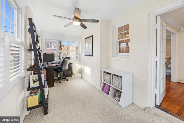 home office featuring a ceiling fan, brick wall, and carpet flooring