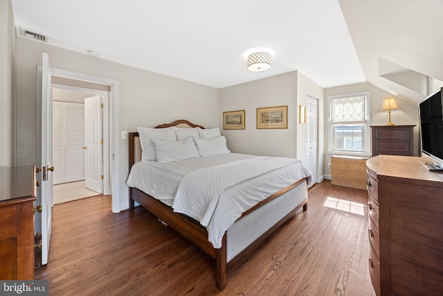 bedroom featuring wood finished floors, visible vents, and baseboards