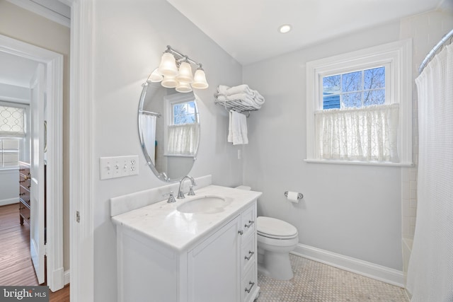 bathroom with baseboards, toilet, and vanity